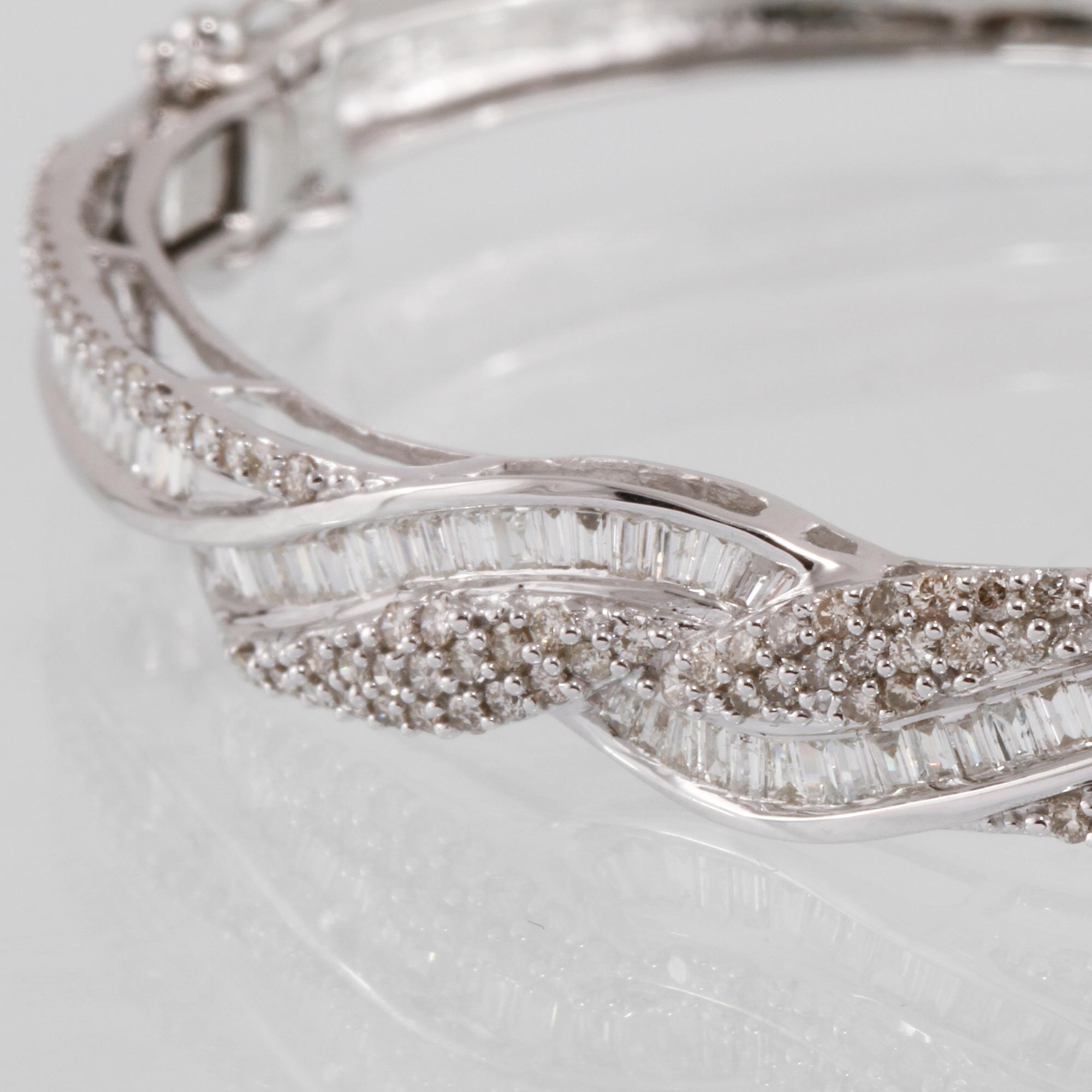 ARMRING, 18K vitguld med briljant och baguettslipade diamanter 1.08 ct. Vikt 12,3 gram.