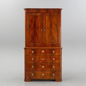 A mahogany veneered Empire cupboard, first half of the 19th century.