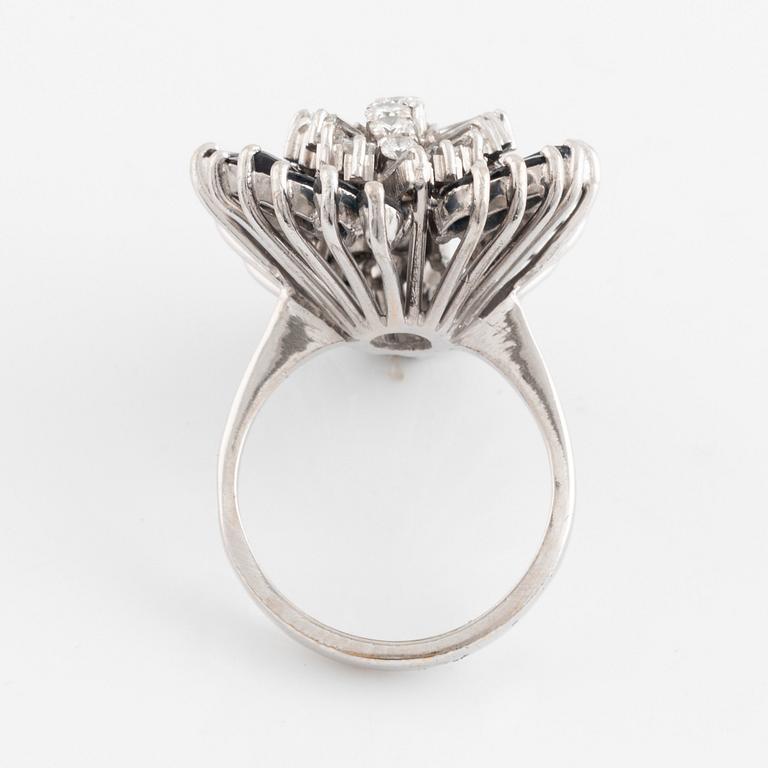 An 18K white gold, navette sapphire and baguette- and round brilliant cut diamond ring.