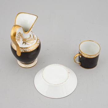 A porcelain jug and a cup with saucer, empire style, circa 1900.