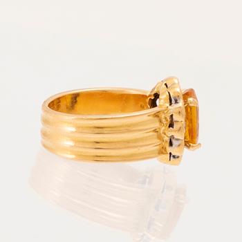 A 22K gold carmosé ring with an oval faceted yellow sapphire and round brilliant-cut diamonds.
