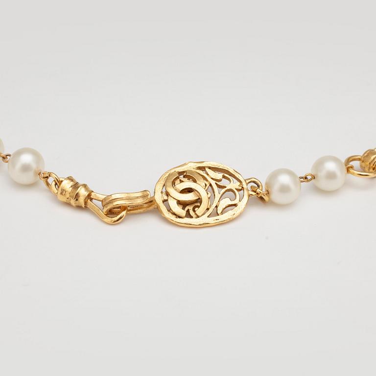 CHANEL, a necklace with white decorative pearls and gold colored embellishment.