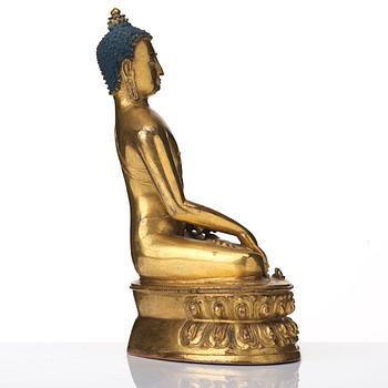 A gilt copper alloy figure of Akhsobya buddha, Tibet, 15th Century.