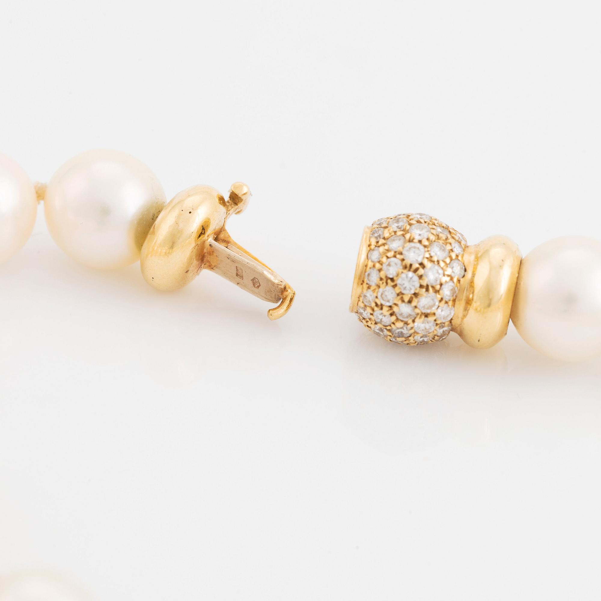 A cultured pearl necklace with a pendant and a pair of earrings.
