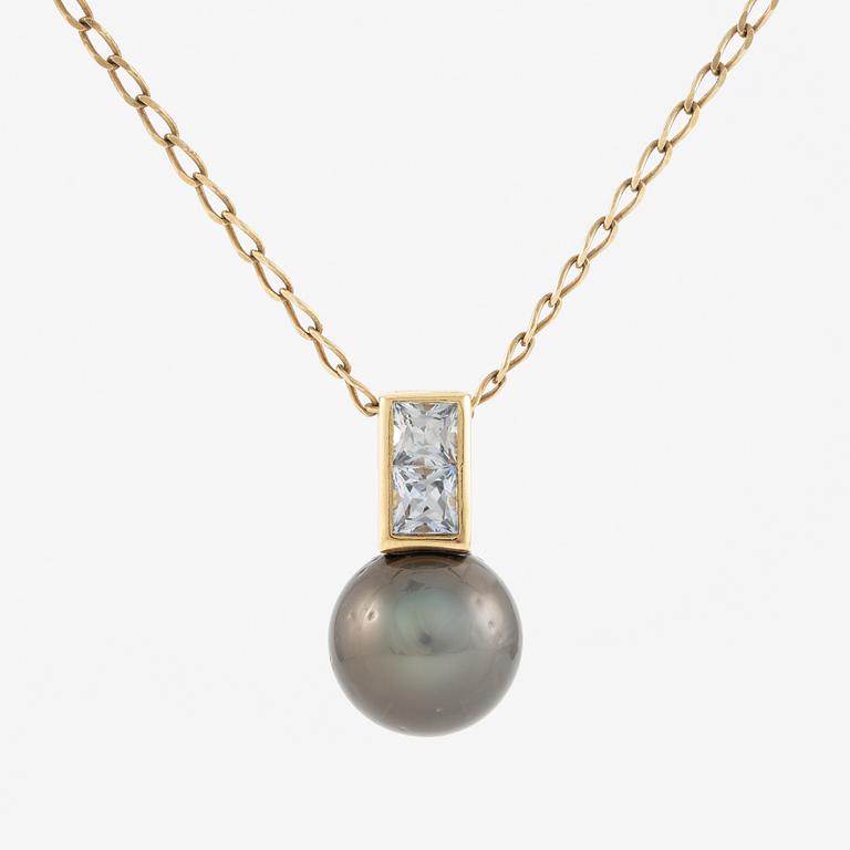 Pendant in 18K gold with a cultured pearl and faceted white stones.