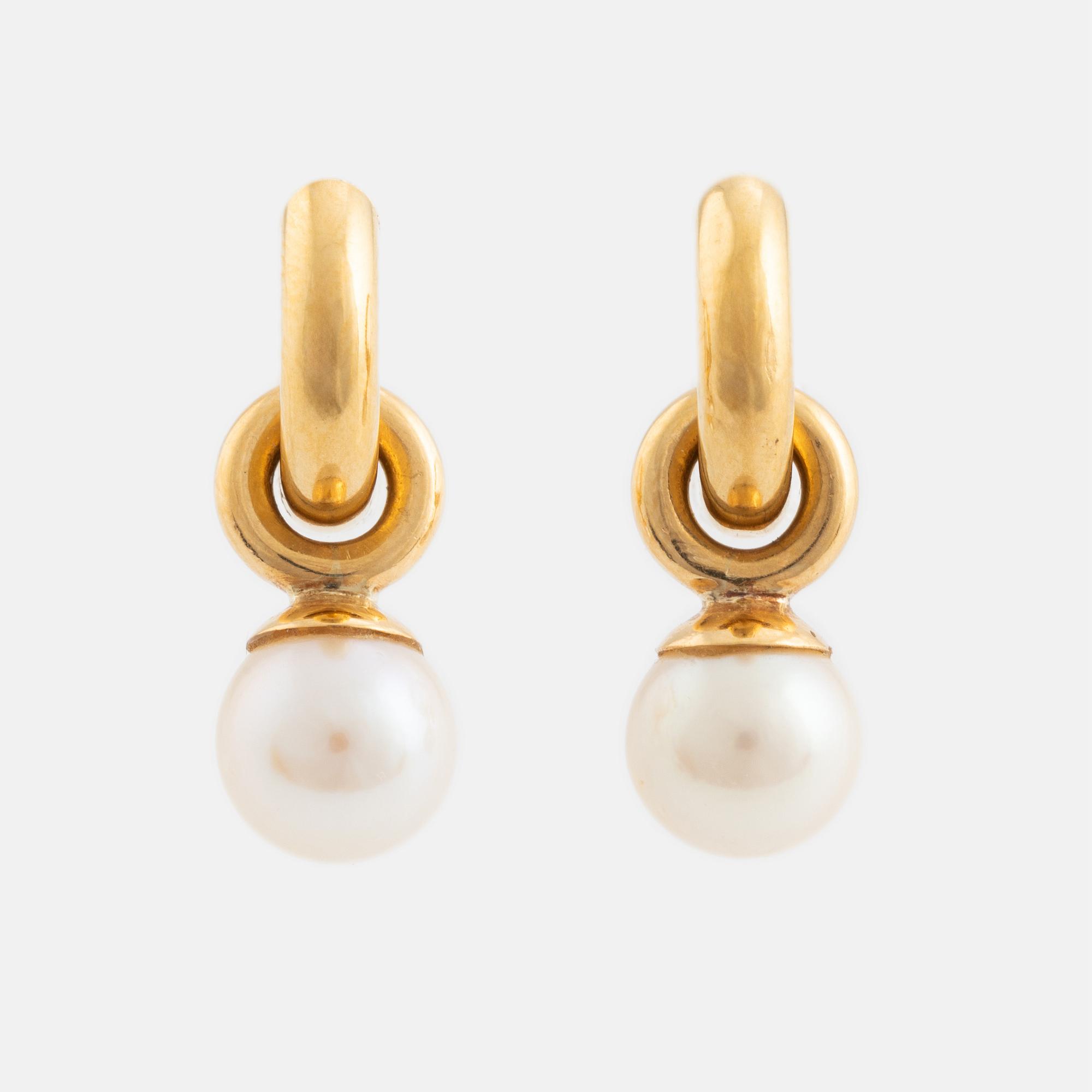 A pair of gold earrings with pearls.