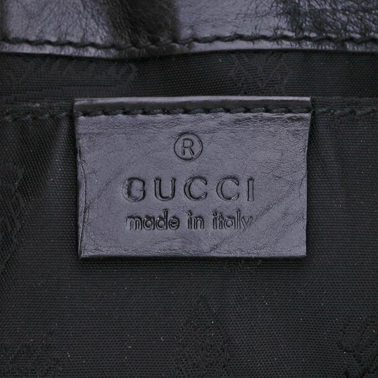 GUCCI, a black leather clutch.