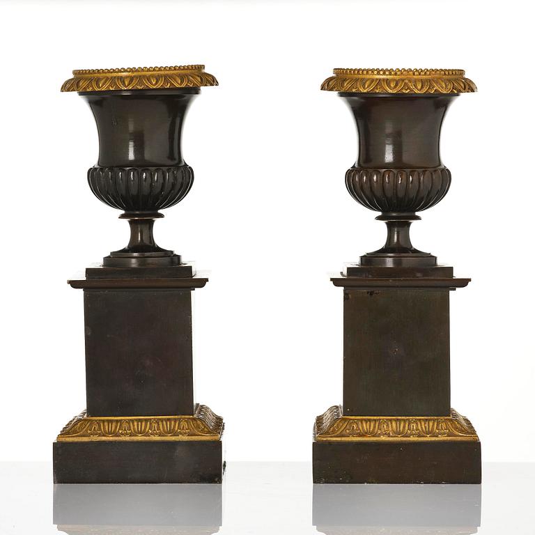 A pair of French Empire ormolu and patinated bronze urns, circa 1820.