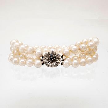 A three-row bracelet of cultured pearls and clasp in 18K white gold.