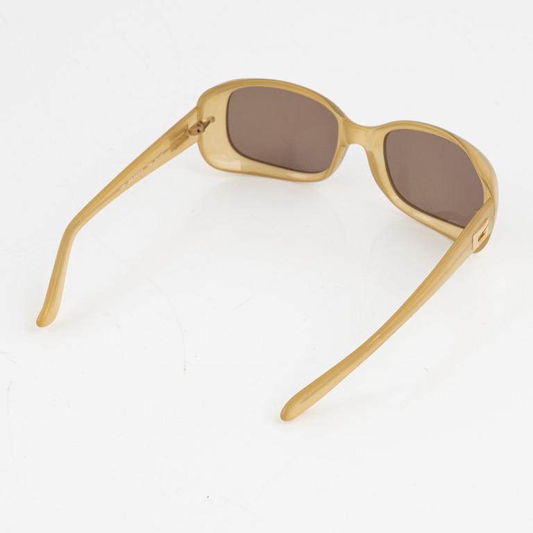 Gucci, a pair of beige sunglasses.