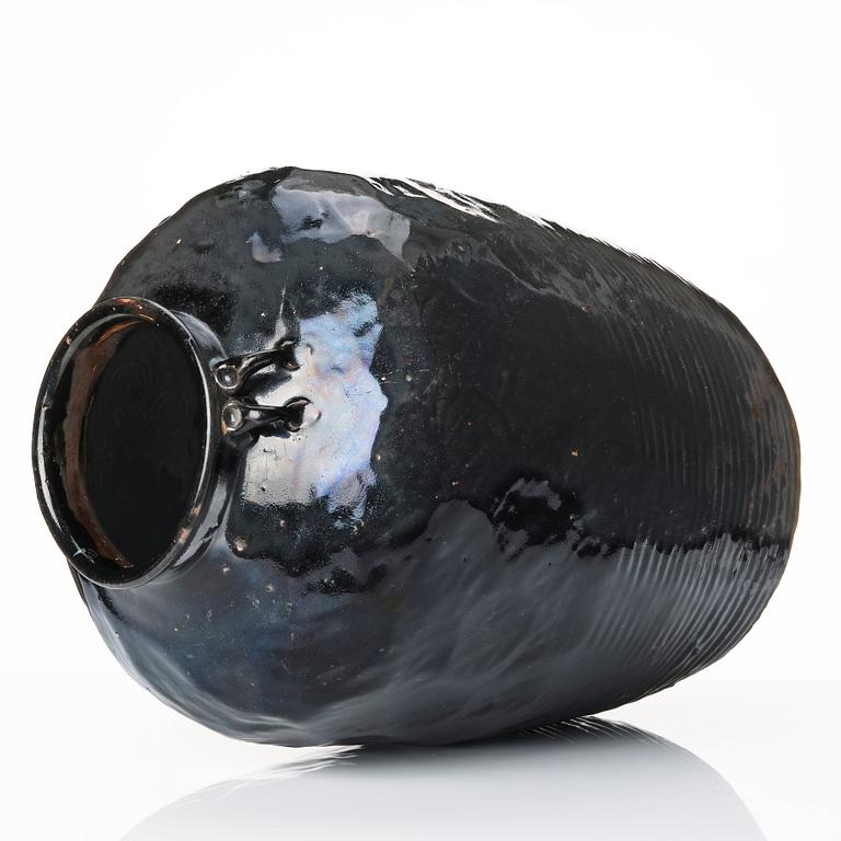 A large black glazed jar, presumably late Ming dynasty.