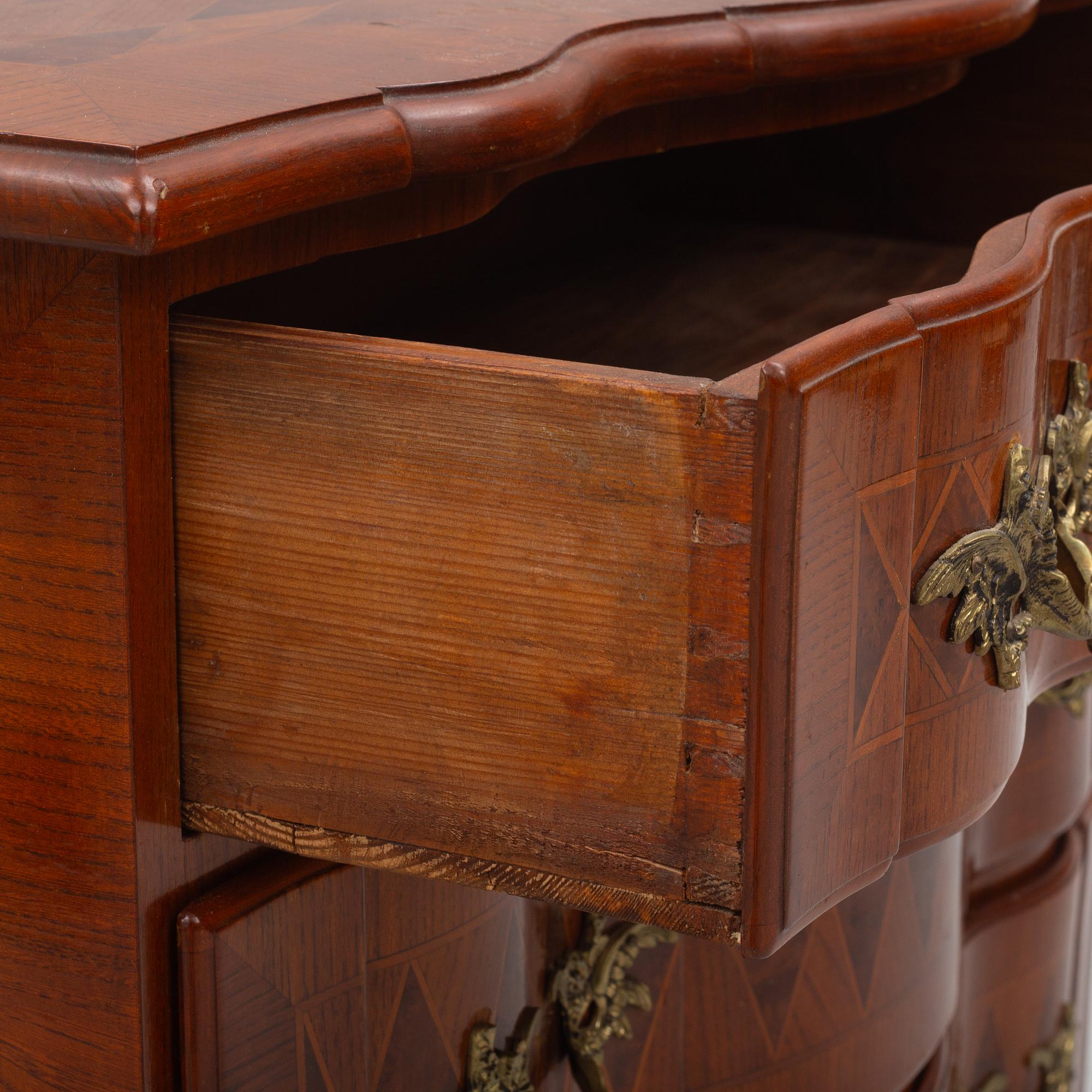 A Baroque style chest of drawers, circa 1900.