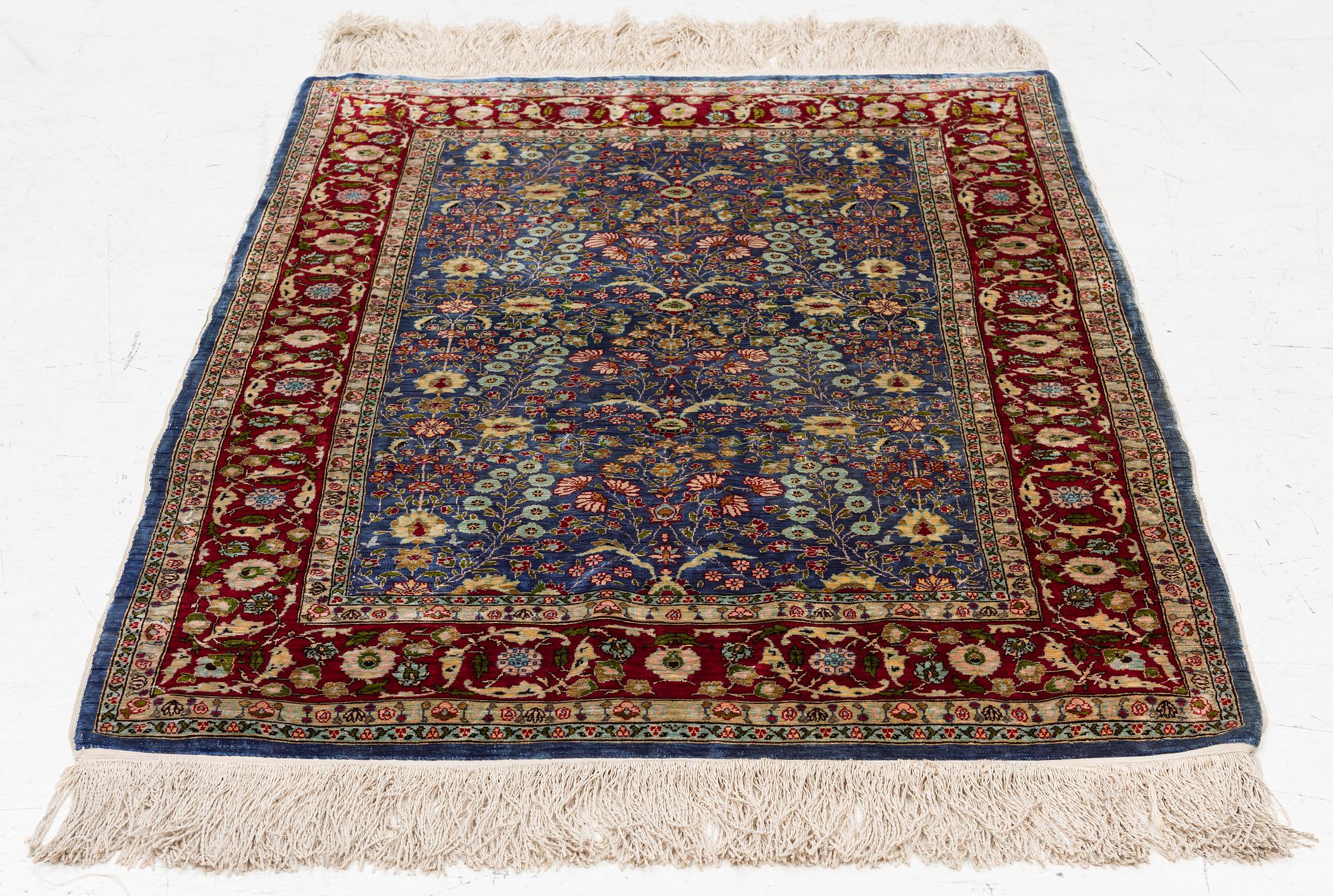 An Oriental silk rug, signed, c. 125 x 85 cm.