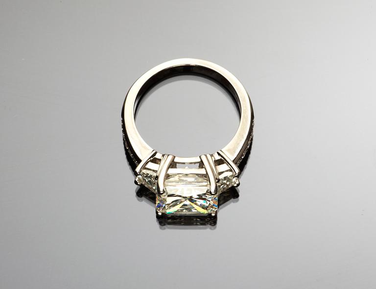 RING, radiant cut diamant 5.01 ct, med trapez- och briljantslipade diamanter på vardera sida.