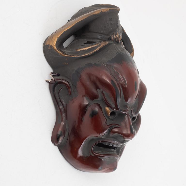 A Japanese lacquered wooden mask, 20th century. Signed.