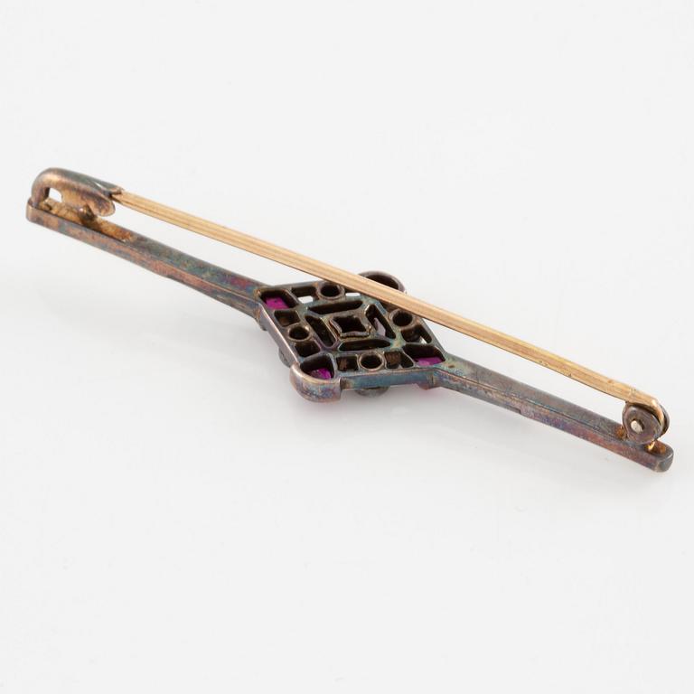 Brooch platinum and 14K gold set with old- and rose-cut diamonds and red stones.