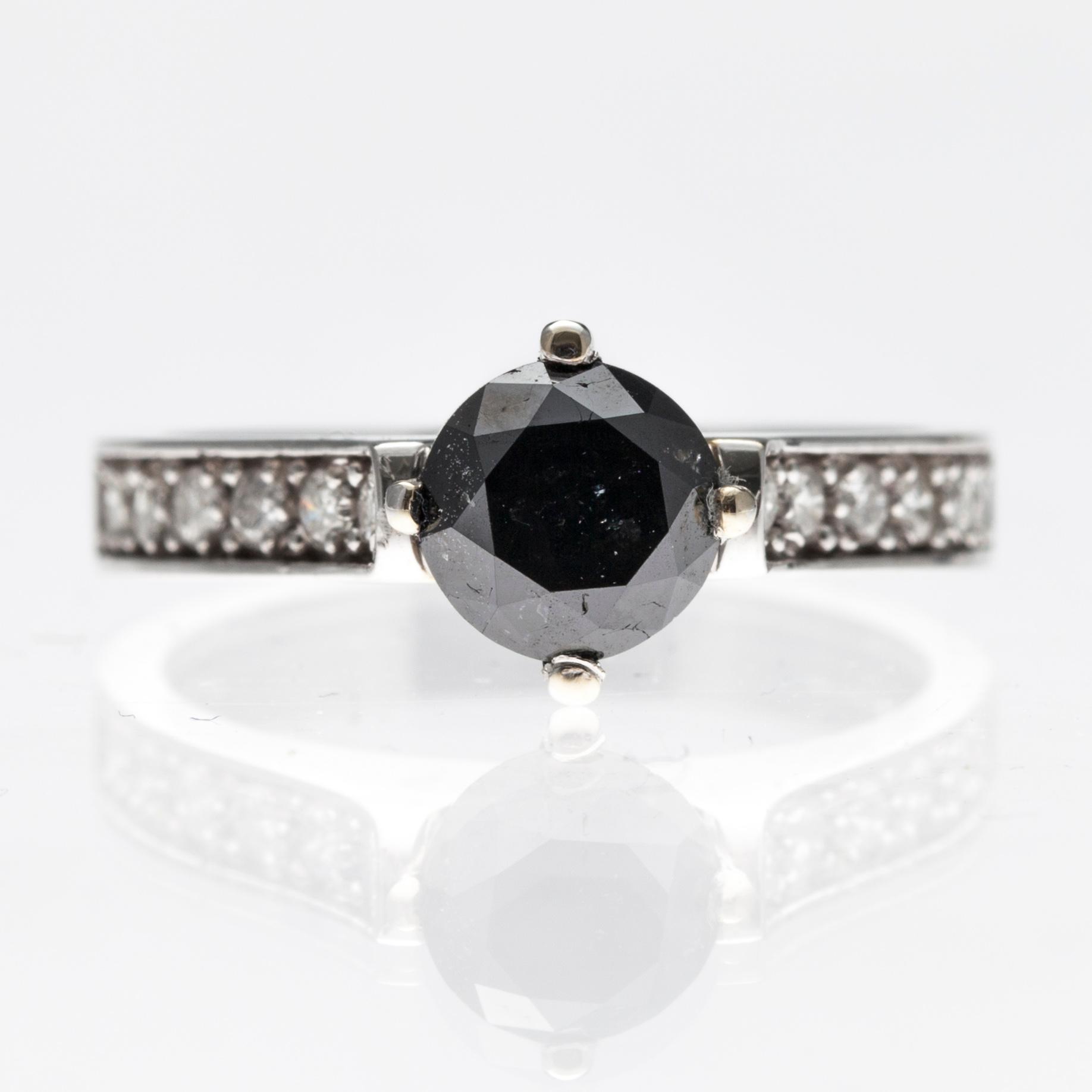 RING, 14K vitguld med en svart samt 12 briljantslipad diamanter ca1,09 ct resp tot ca 0,24ct. Tot vikt 3,5 g.