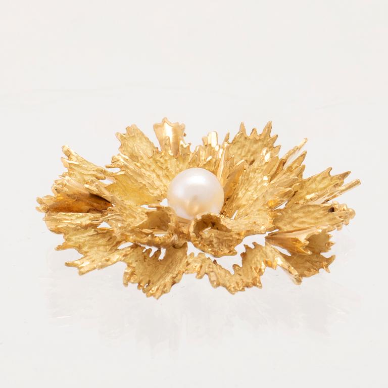 An 18K gold brooch set with a cultured pearl.
