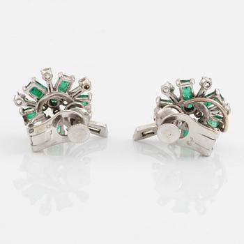 A pair of 14K white gold, emerald and round brilliant- and baguette cut diamond ear clips.