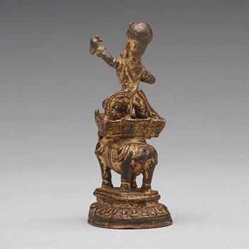 A gilt bronze figure of a deity on an elephant, presumably Nepal, 15th Century.