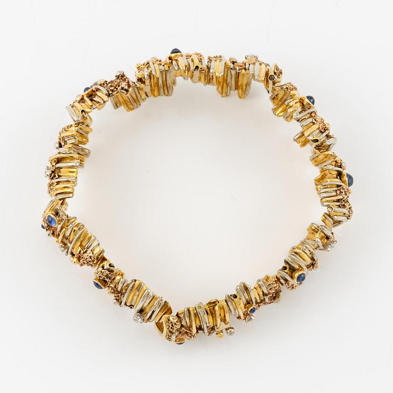 An 18K gold bracelet set with round brilliant-cut diamonds and cabochon-cut sapphires.
