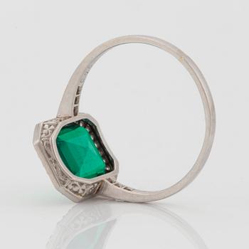 A platinum ring set with a Colombian step-cut emerald and old-cut diamonds in a fitted case from Cartier.