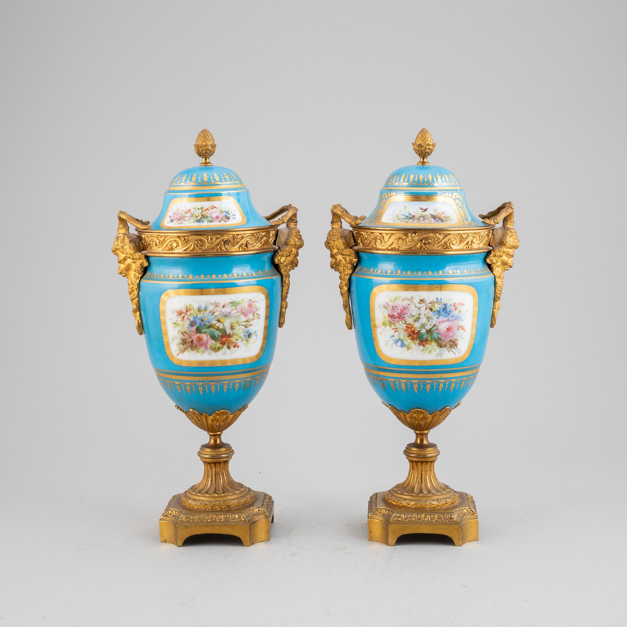 A pair of pordelain and gilt brass urns in teh style of Sevres, 20th Century.