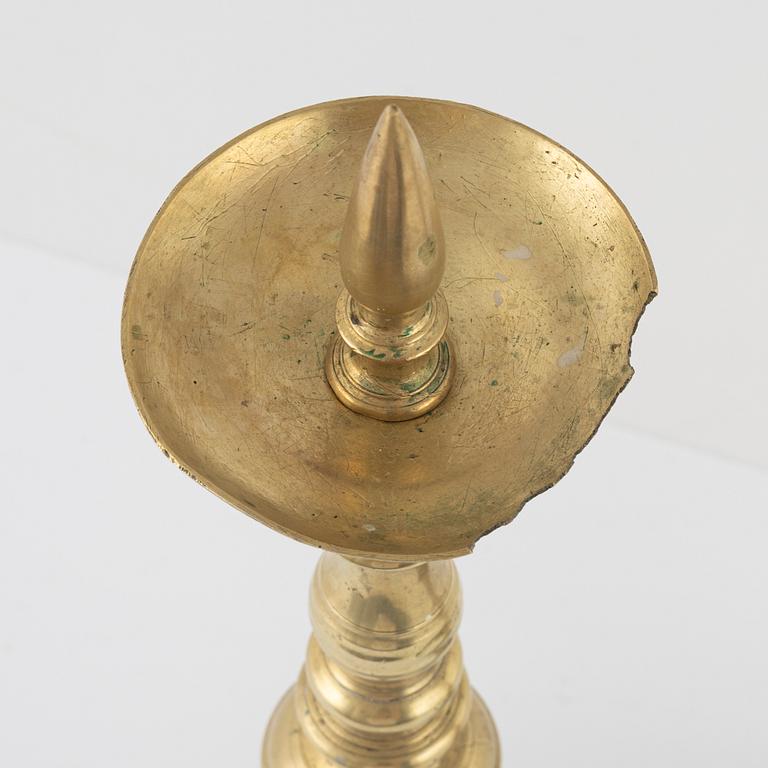 A pair of brass candle sticks, around 1700.
