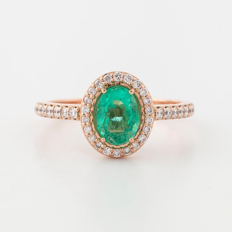 An oval cut emerald and brilliant cut diamond ring.