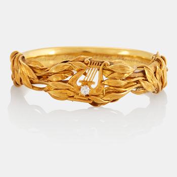 An 18K gold bangle set with an old-cut diamond.