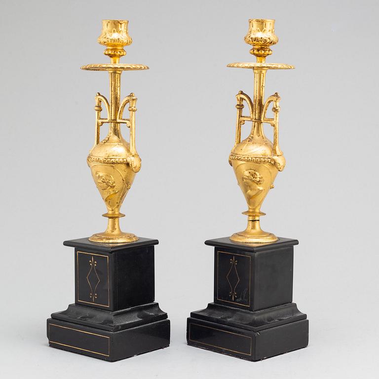 A late 19th century table clock and a pair of candlesticks.