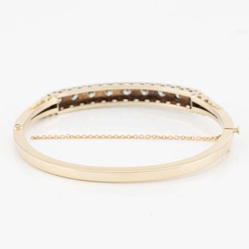 Bangle in 18K gold with round brilliant-cut diamonds.