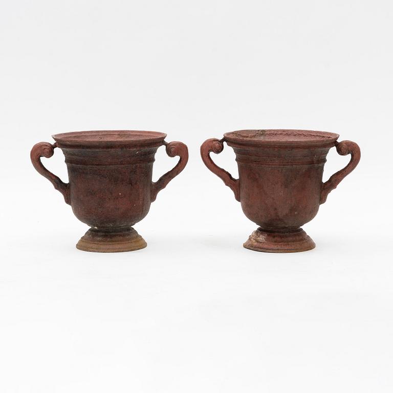 A pair of cast iron garden urns, 20th Century.