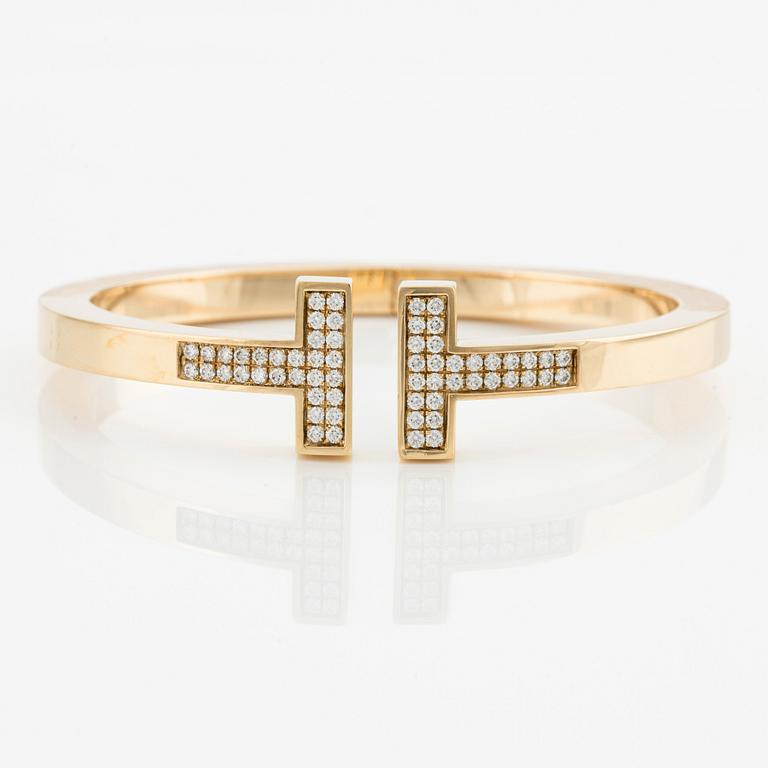 An 18K gold Tiffany & Co bracelet "Tiffany T"  with round brilliant-cut diamonds.