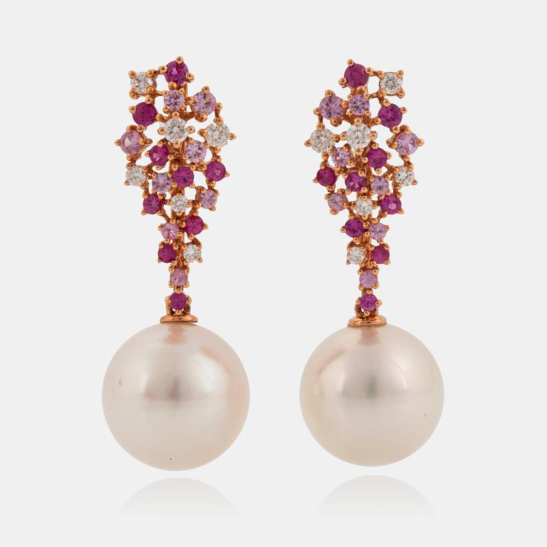 Ett par örhängen med odlade Söderhavspärlor samt runda briljantslipade diamanter och rosa safirer.