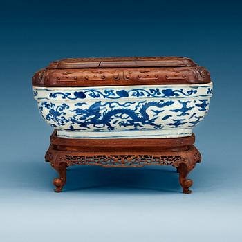 1853. A blue and white five clawed dragon box with a wooden cover and stand, Ming dynasty with Wanli six character mark.