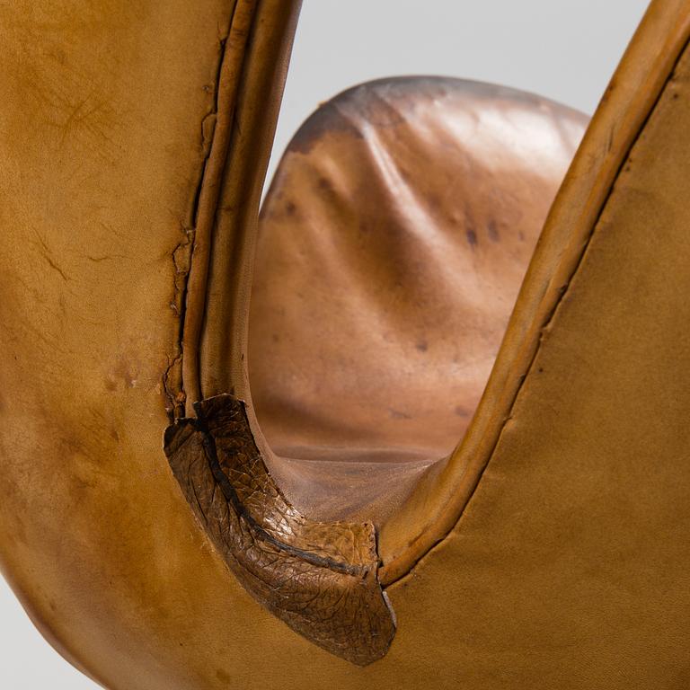 An Arne Jacobsen steel and brown leather 'Swan' chair, Fritz Hansen, Denmark 1960's.