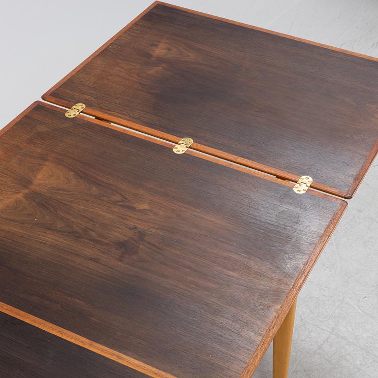 A 1960's teak and rosewood veneered dining table.