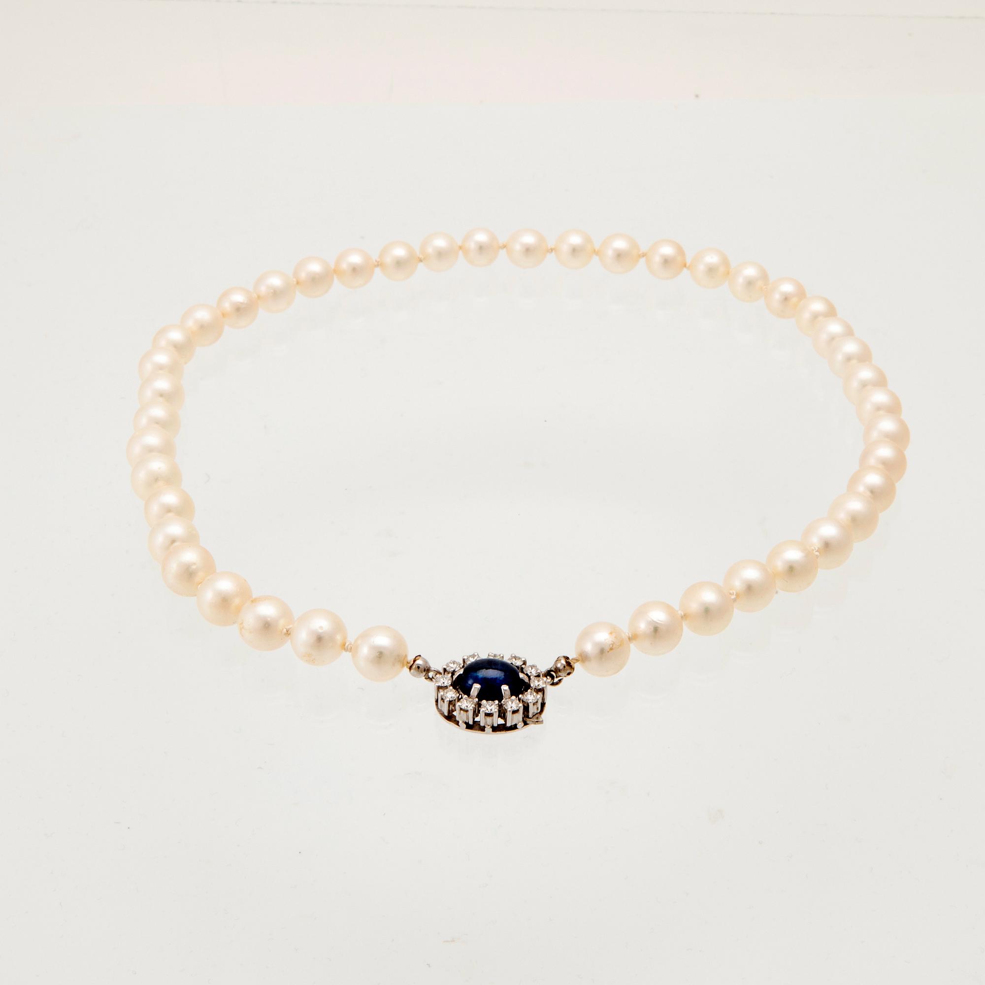 Necklace with cultured pearls, clasp in 18K white gold with cabochon-cut sapphire and round brilliant-cut diamonds.
