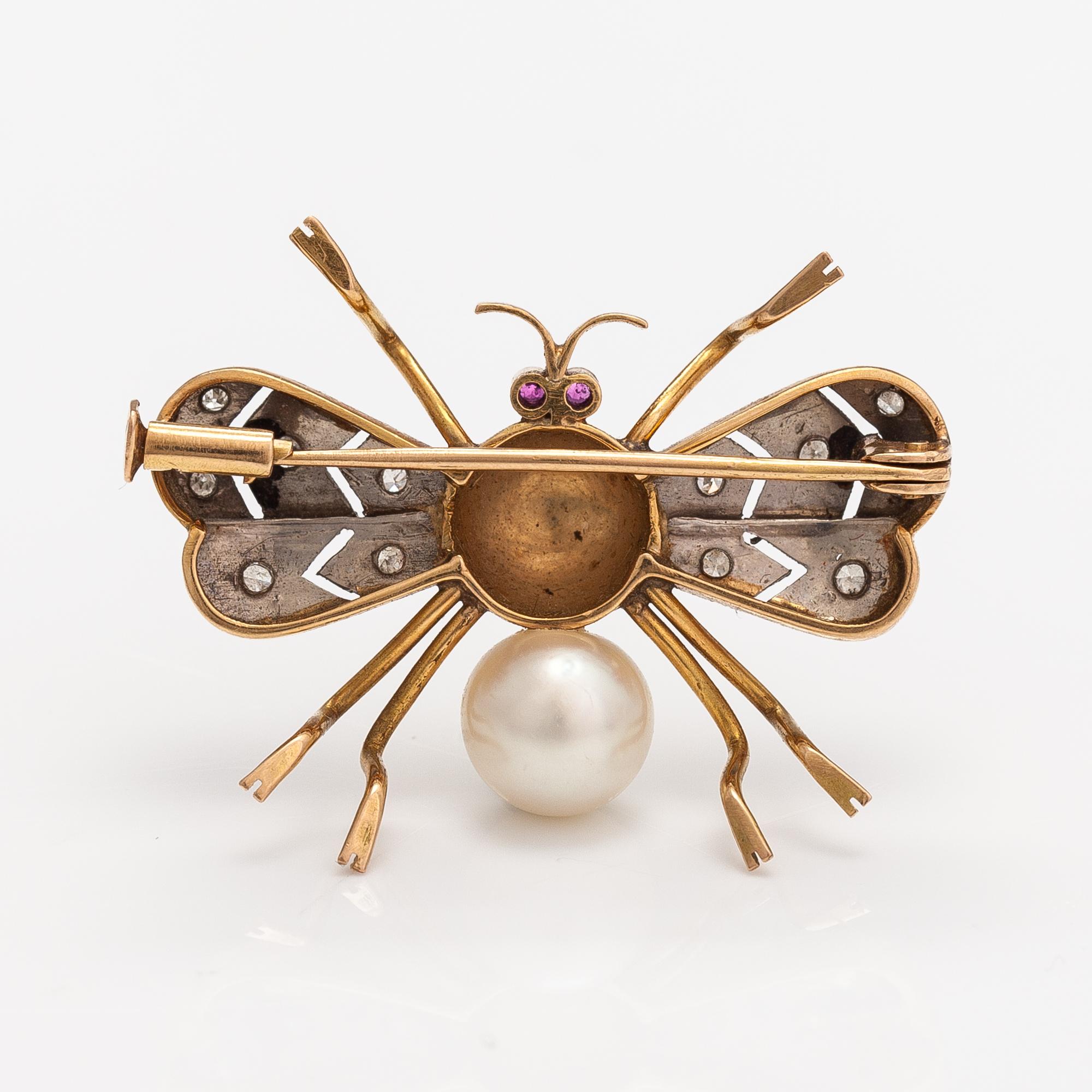 A 15-17K gold brooch with rubies, a cultured pearl and diamonds ca. 0.10 ct in total.