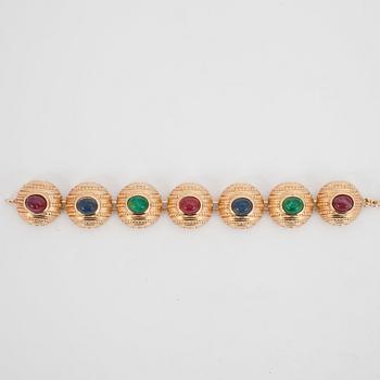 CHRISTIAN DIOR, a gold colored metall braclet with decorative glass stones.