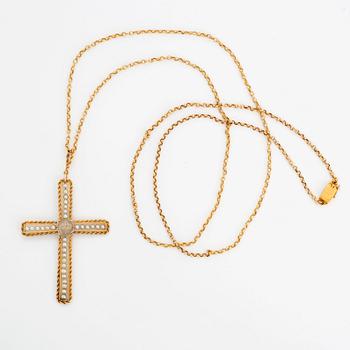 An 18K gold and pearl cross pendant with a gold chain.