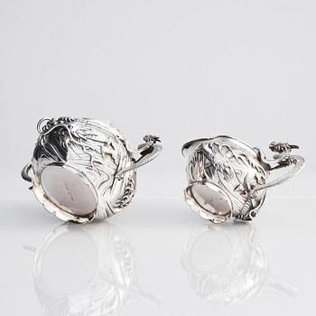 A three piece japanse silver 'dragon' tea set, Signed 三代目 大島, third generation Oshima, early 20th Century.