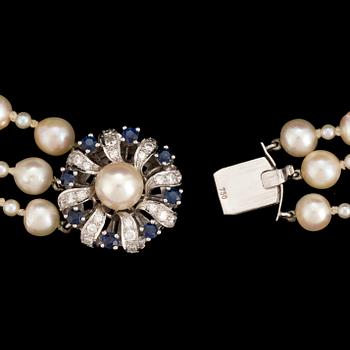 A necklace of baroque-shaped, cultured pearls with a clasp in 18K white gold decorated with diamonds and sapphires.