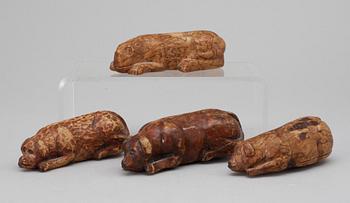 219. Four 19th-20th century birch snuffboxes i the shape of lying dogs.