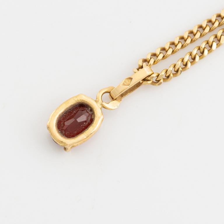 Pendant with chain with red stone, possibly garnet.