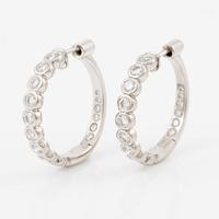 A pair of earrings in 18K white gold set with round brilliant-cut diamonds.