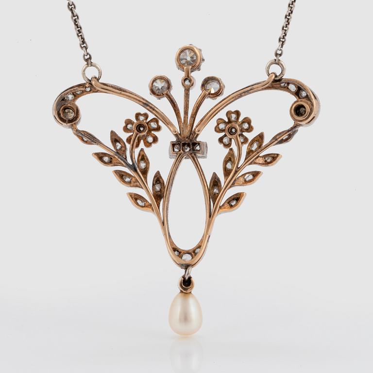 A pendant/brooch in 14K gold and platinum set with old- and rose-cut diamonds and a pearl.