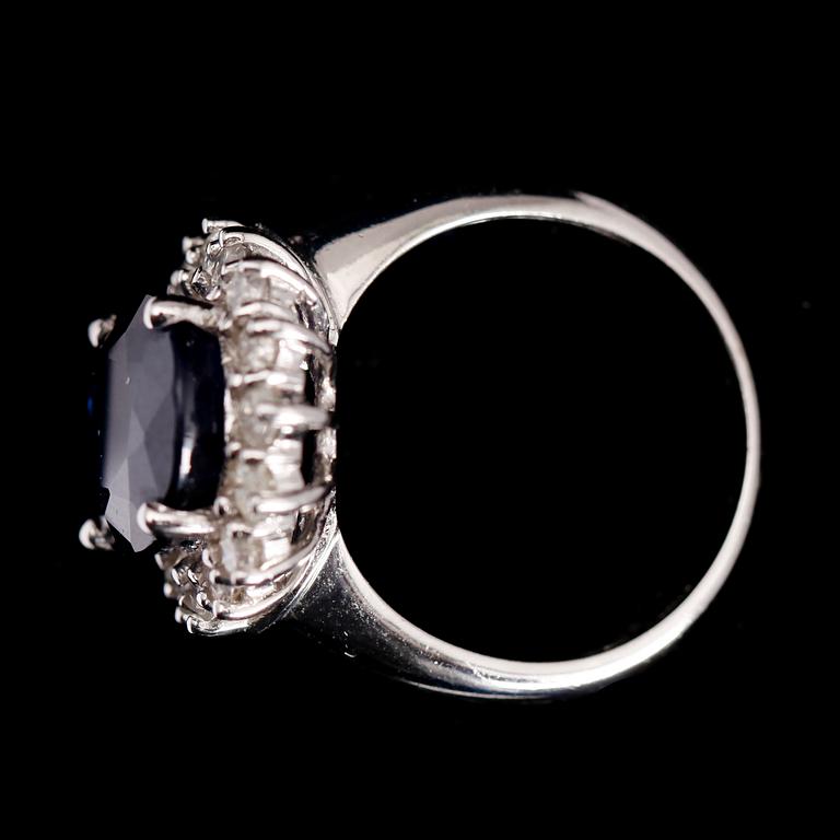 RING, 10 k vitguld, mörkblå safir ca 6.0 ct samt diamanter tot ca 1.0 ct.