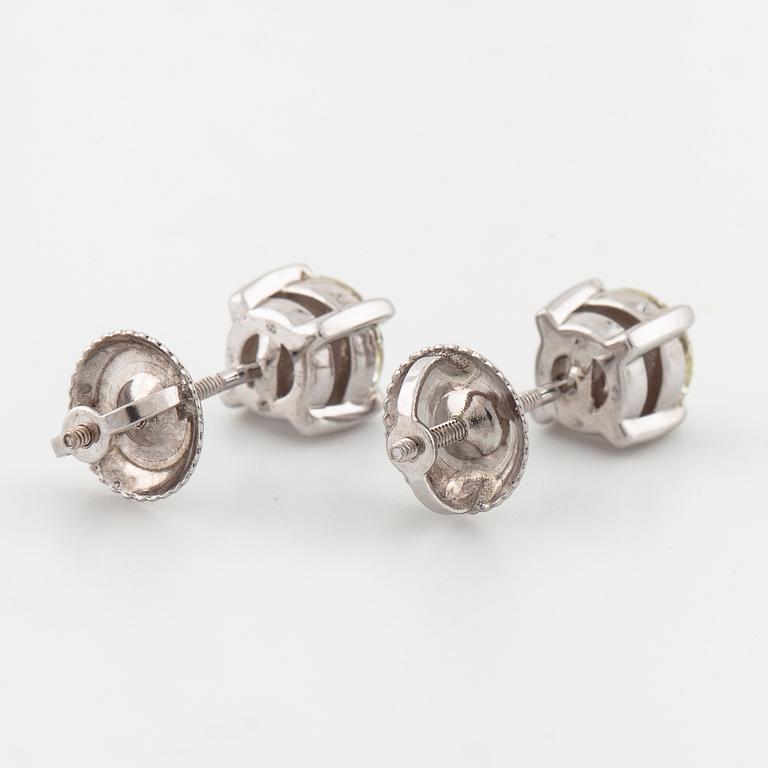 A pair of brilliant cut diamond earrings.